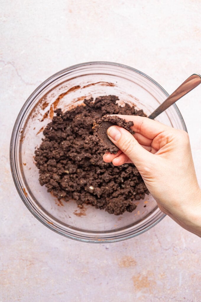 hand pressing crust dough in bowl