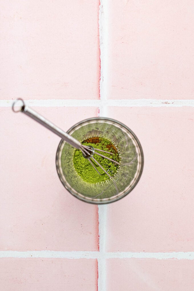 whisk with matcha in glass