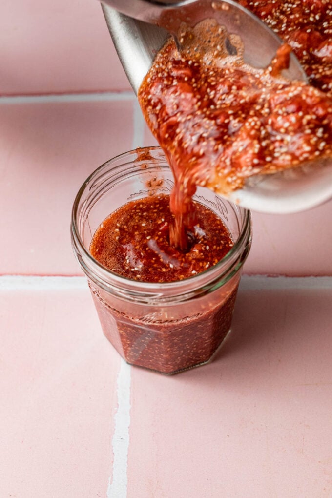 pouring chia jam into a jar