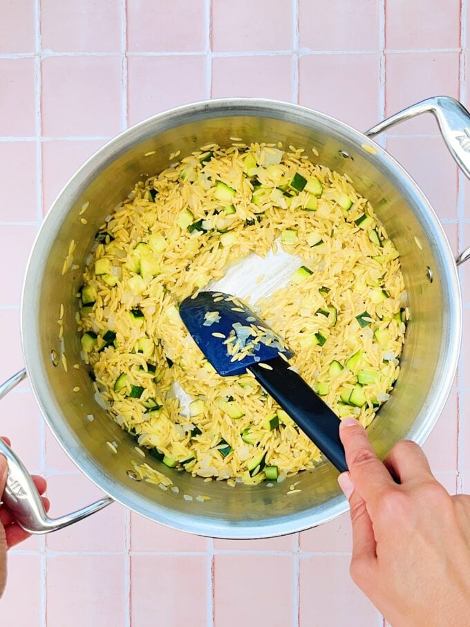 hand stirring orzo