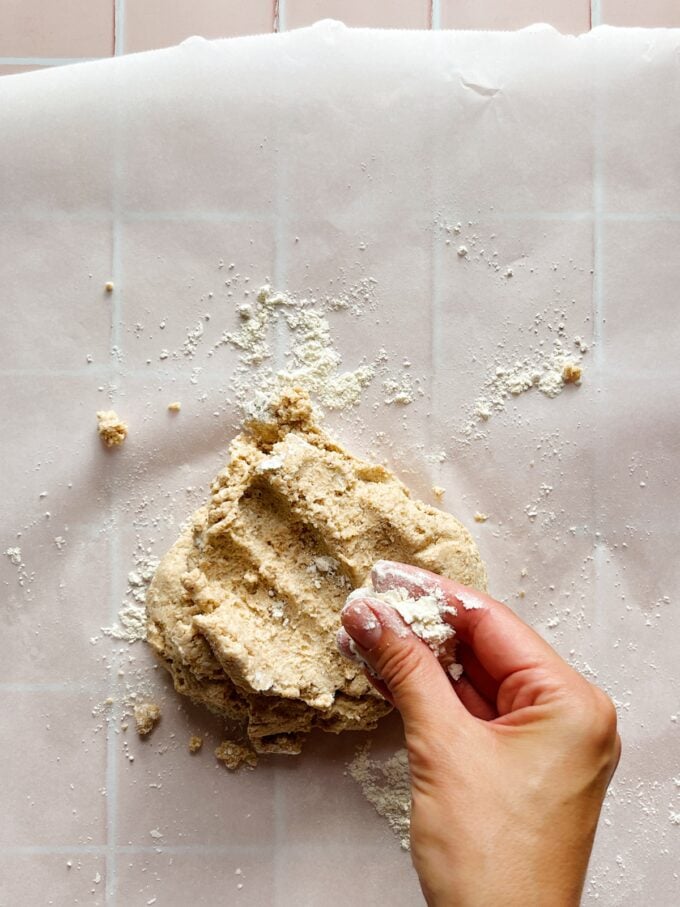 hand sprinkling flour on dough