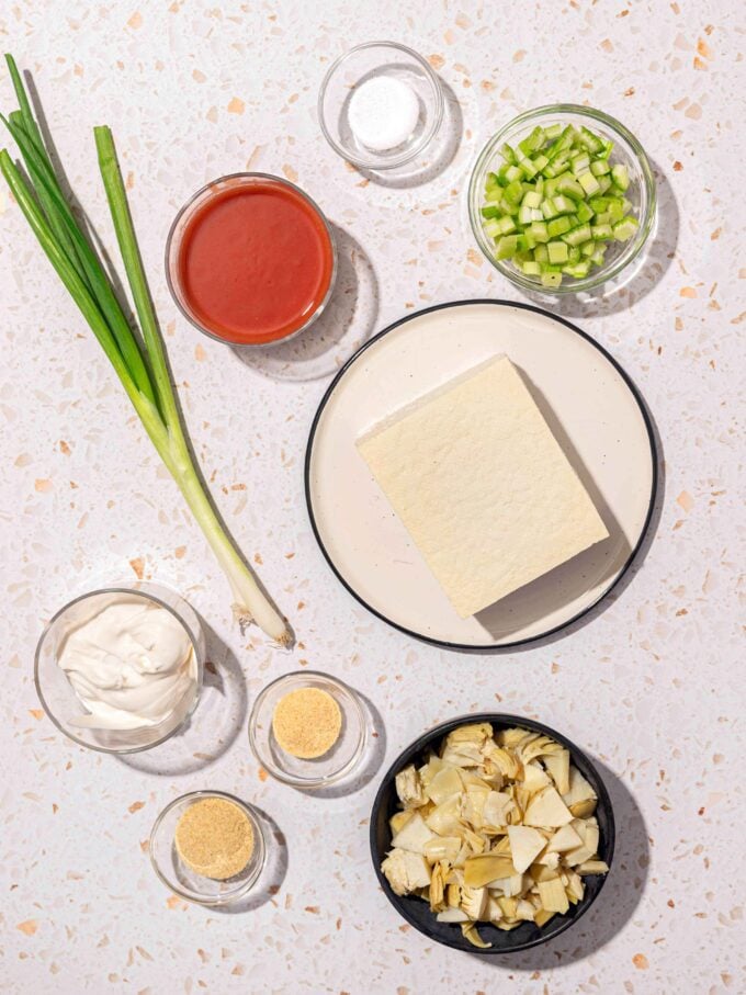 tofu on plate with vegetables and hot sauce