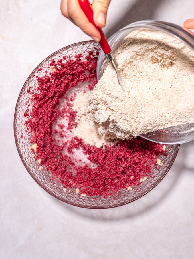 pouring flour into pink cookie dough