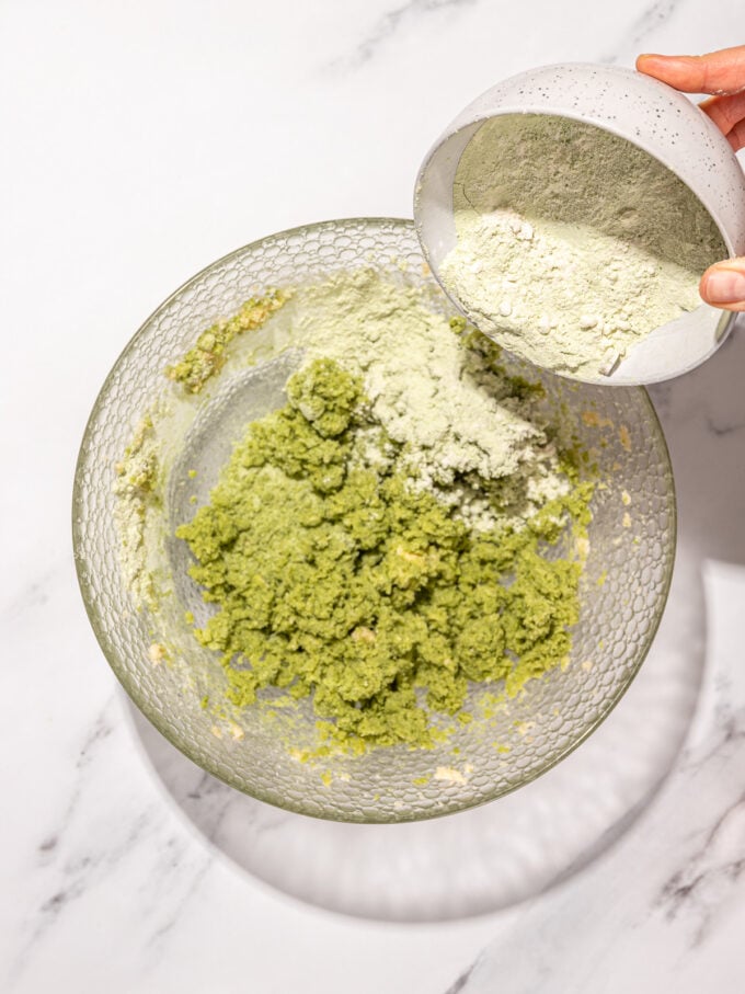 pouring flour into matcha cookie batter