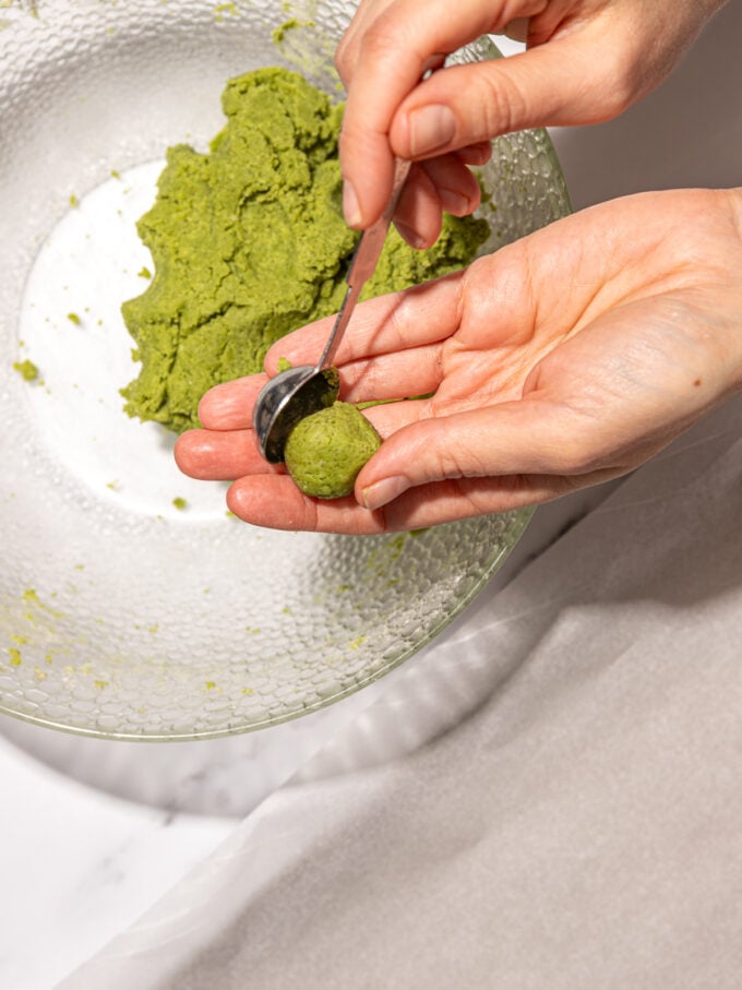 hand scooping matcha cookie dough