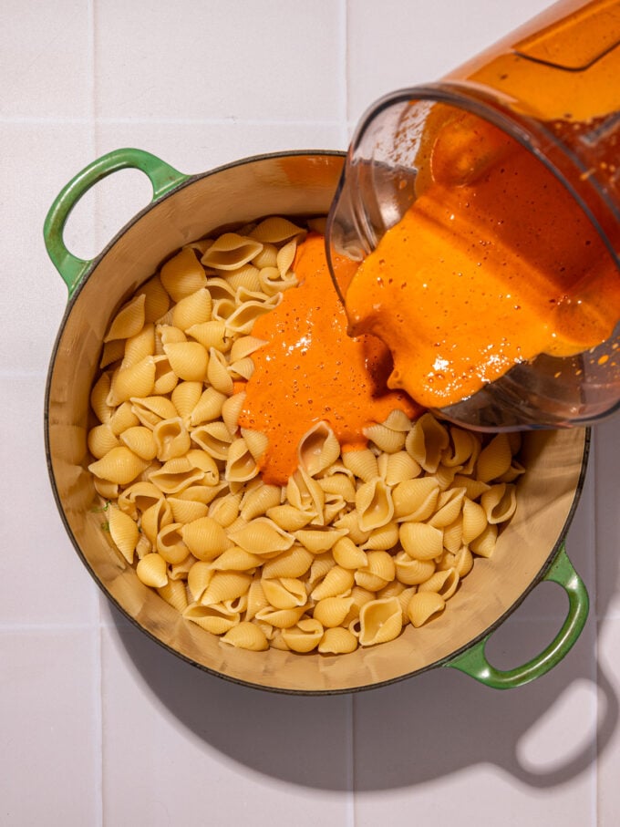 pouring silken tofu sauce over pasta