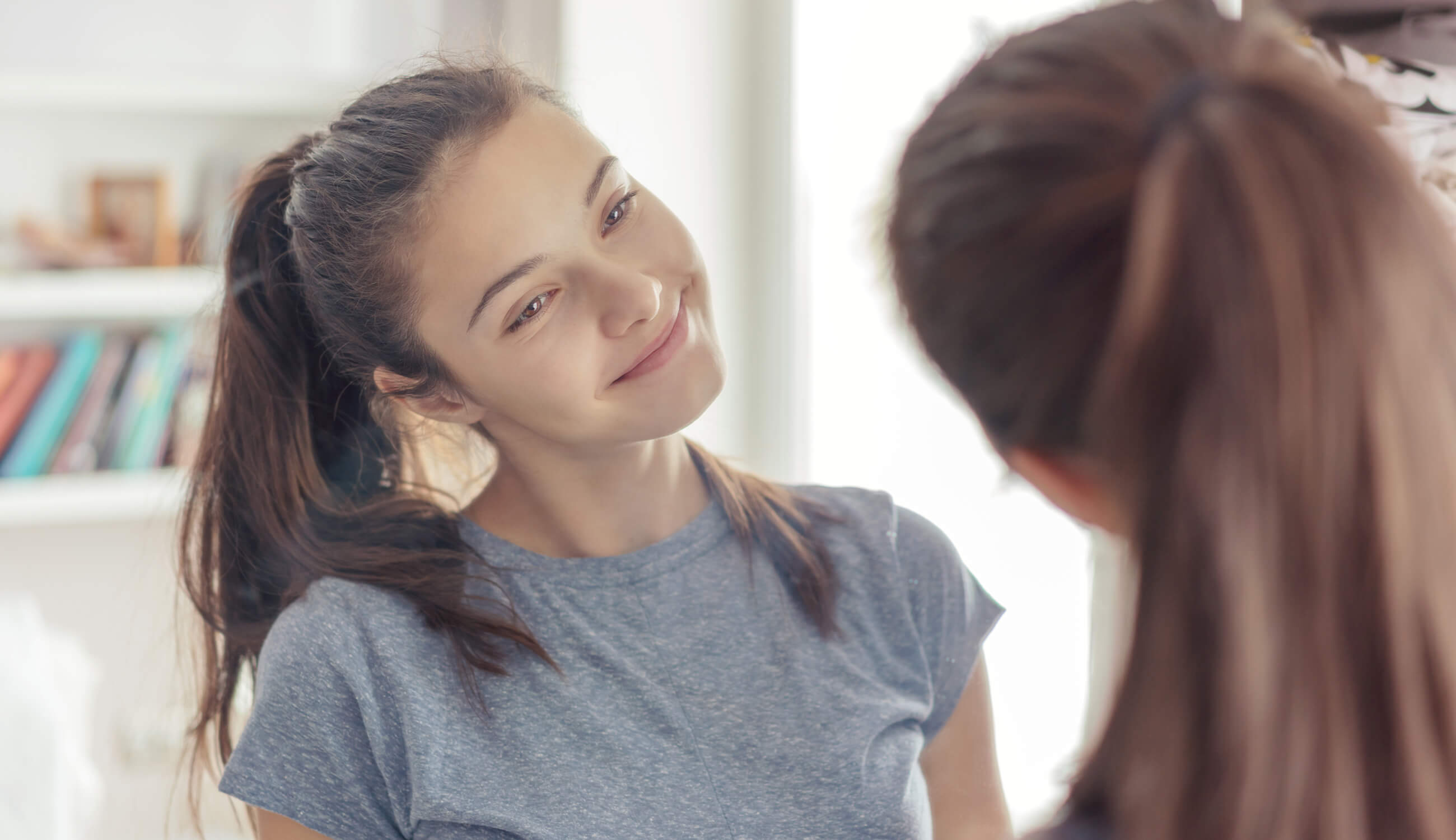 Teen girl looking at her skin in the mirror