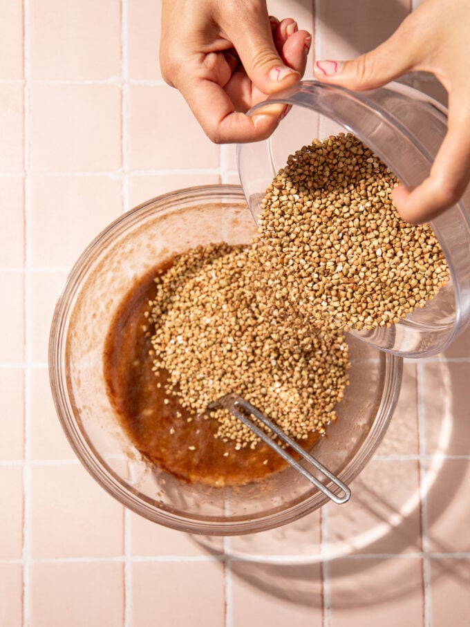 hand pouring buckwheat into bowl