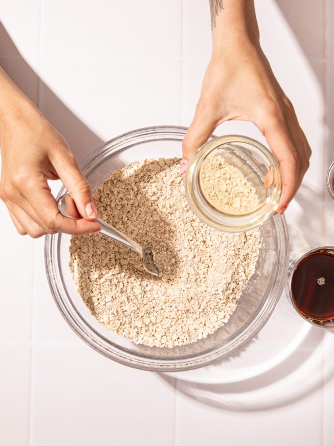 oats in bowl with hand stirring