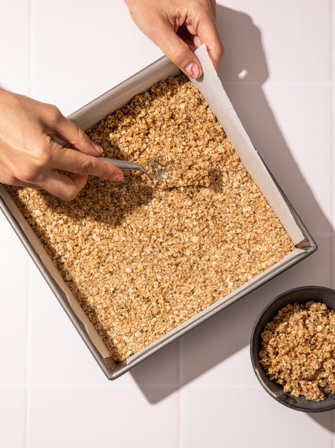 hand pressing oatmeal bar base