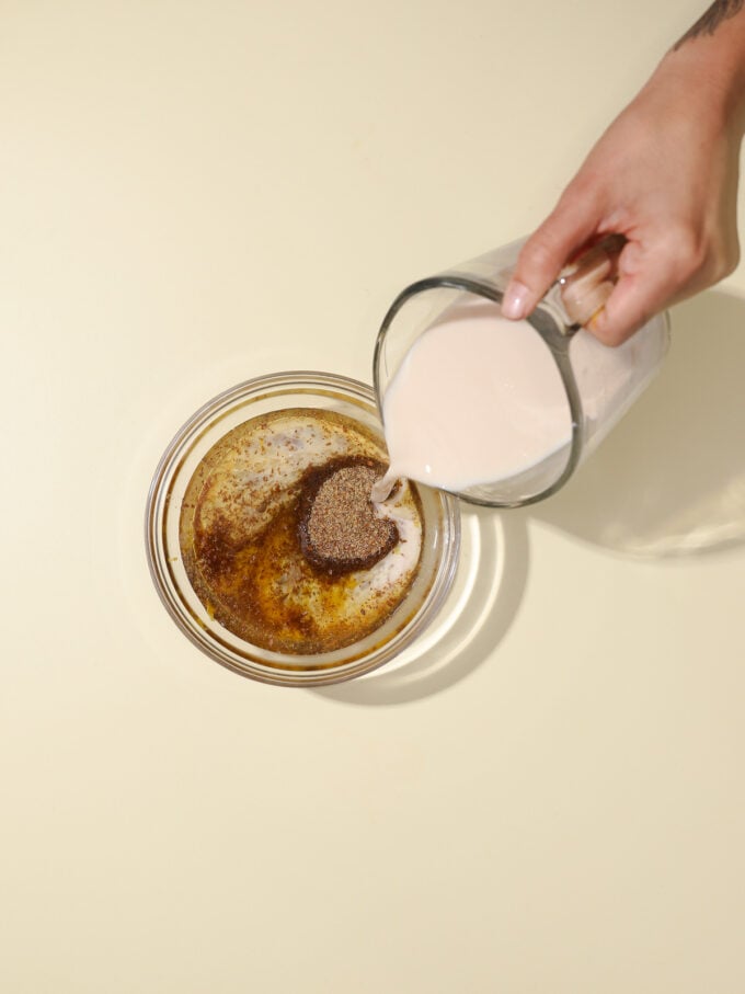 hand pouring milk into bowl