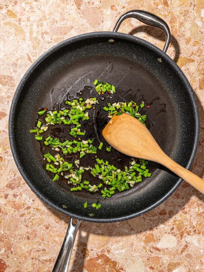 wooden spoon with kale in skillet