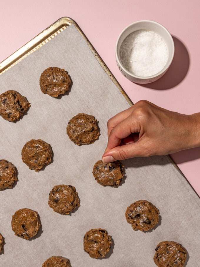 hand sprinkling salt on cookies