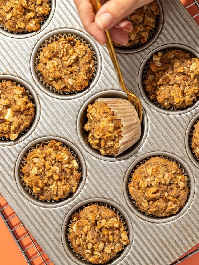 hand turning over a muffin in a muffin pan