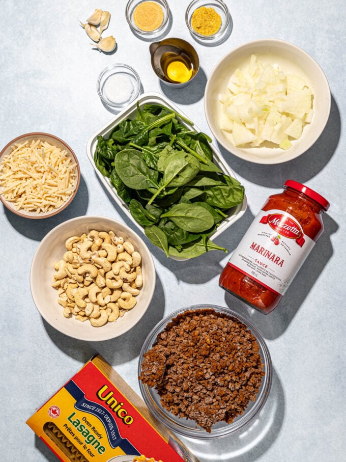 pasta sauce, cashews, veggie ground, spinach and lasagna in bowls