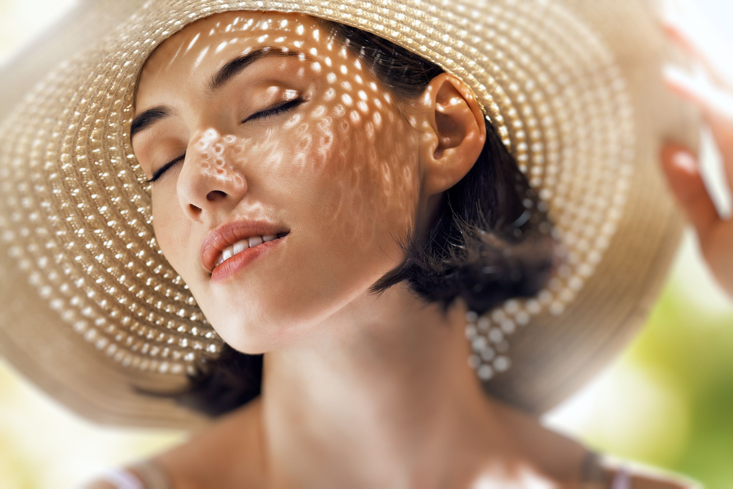 Woman_in_a_hat_protecting_her_face_from_the_summer_sin